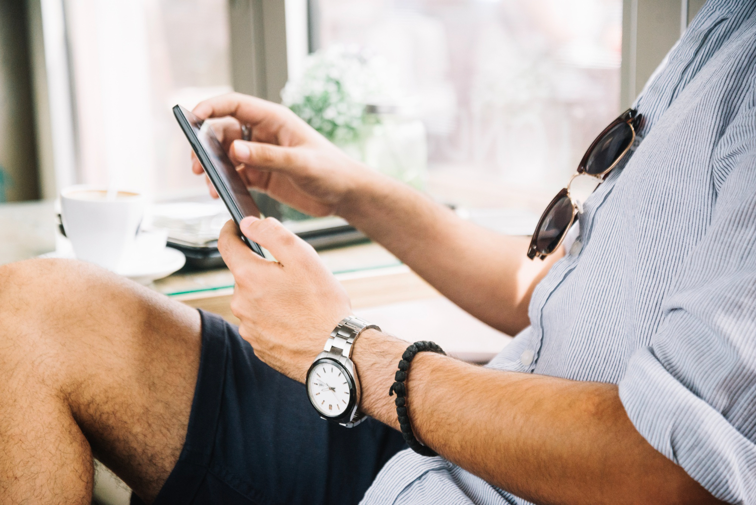 a man sits at a table and uses a tablet